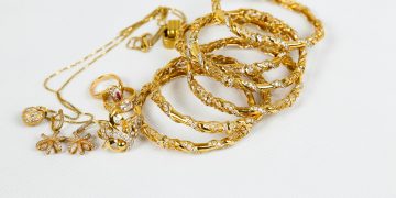 gold chain necklace on white surface