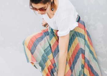 woman wearing white shirt and yellow, blue, and green striped long skirt