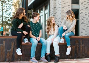 a group of young women sitting on a bench