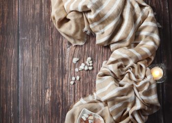 a wooden table topped with candles and a scarf
