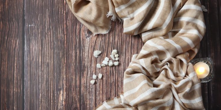 a wooden table topped with candles and a scarf
