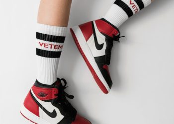 person wearing pair of black toe Air Jordan 1's