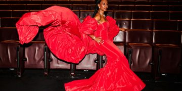 A woman in a red dress sitting on a chair