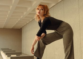 a woman in black shirt and pants standing on a bench