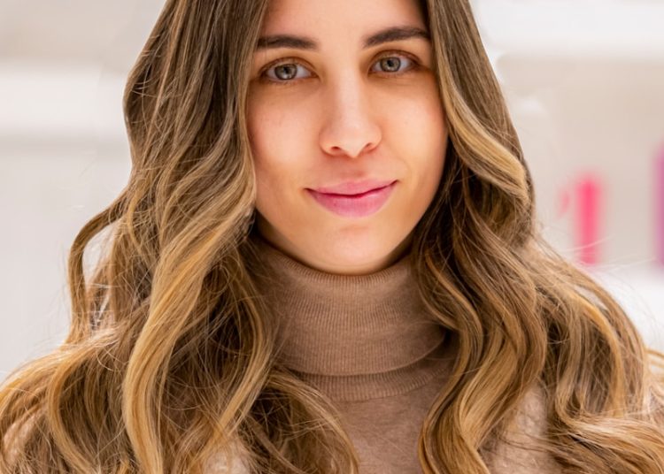 a woman with long hair wearing a coat