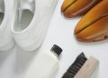 a pair of white shoes next to a white shoe brush