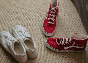 a pair of red and white tennis shoes on the floor