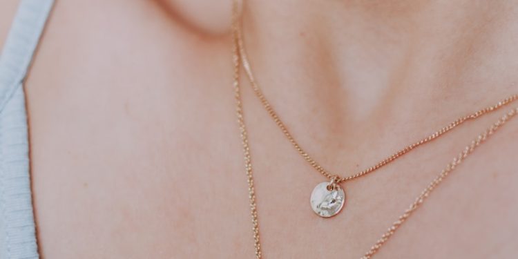 woman wearing gold necklace with silver pendant